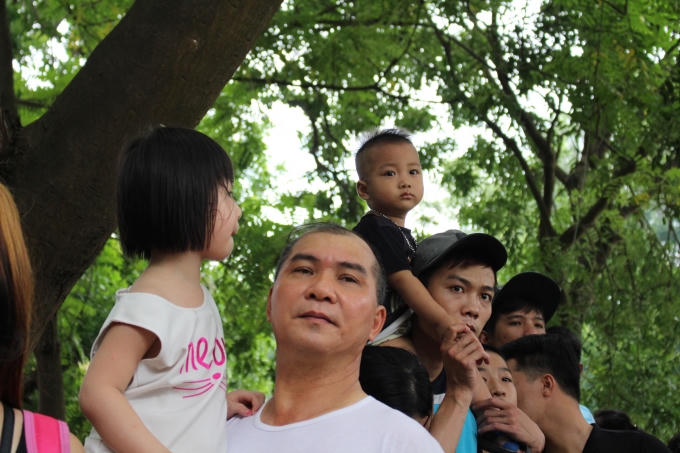 Những đứa trẻ phải nhờ đến sự trợ giúp của phụ huynh mới có thể di chuyển qua dòng người đông nghịt.