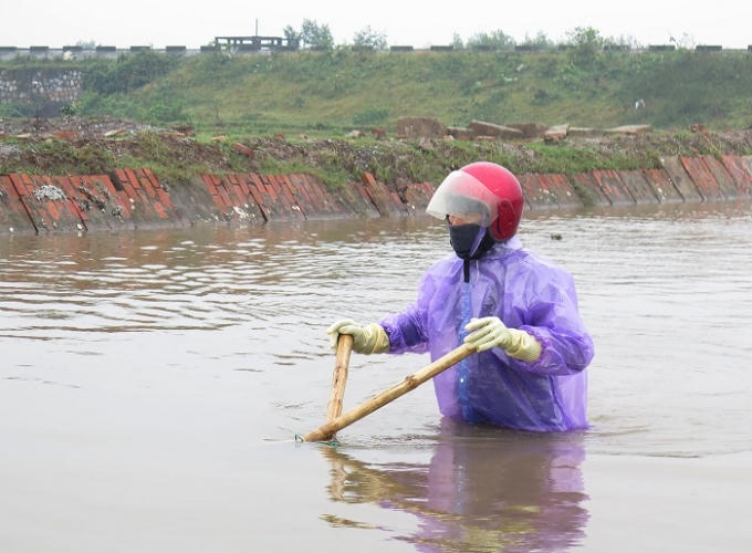 Giữa trời rét hại, người dân phải đánh bắt những con cá còn sống sót và cả những con cá chết còn nằm dưới lòng đầm. Ảnh: CTV Hải An. 