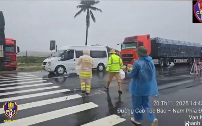 Lực lượng Cảnh sát giao thông phát cơm, nước uống cho lái xe và người dân bị kẹt lại trên tuyến do mưa bão. (Ảnh: Cục CSGT)