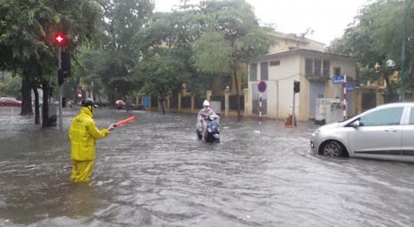 Nhân viên thoát nước và công việc quen thuộc mỗi khi trời mưa. (Ảnh: Tiến Nguyên)