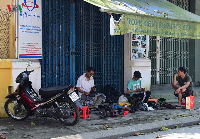 Những người thợ sửa giày đang đánh xi giày cho những khách hàng cuối cùng trong năm.