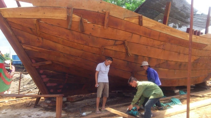 Ông Đinh Khắc Thăng, (áo trắng) Phó chủ nhiệm HTX đóng tầu Lập Lễ đang giám sát công nhân hoàn thiện ốp vỏ thân tầu