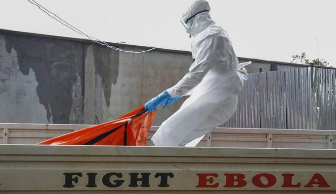 Nhân viên y tế chuyển thi thể một nạn nhân chết do nhiễm virus Ebola tại Monrovia, Liberia. Ảnh: EPA