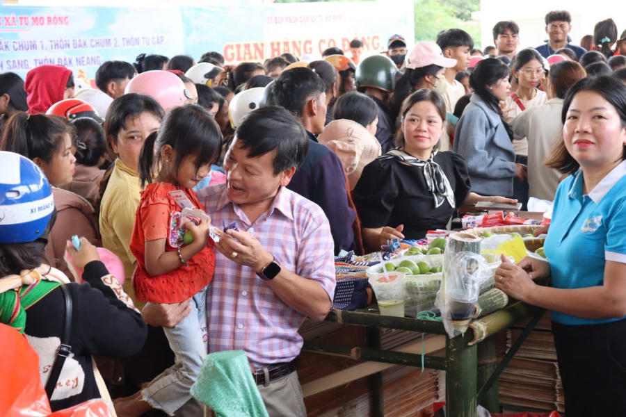 Cán bộ xã Tu Mơ Rông và người dân tham quan phiên chợ.