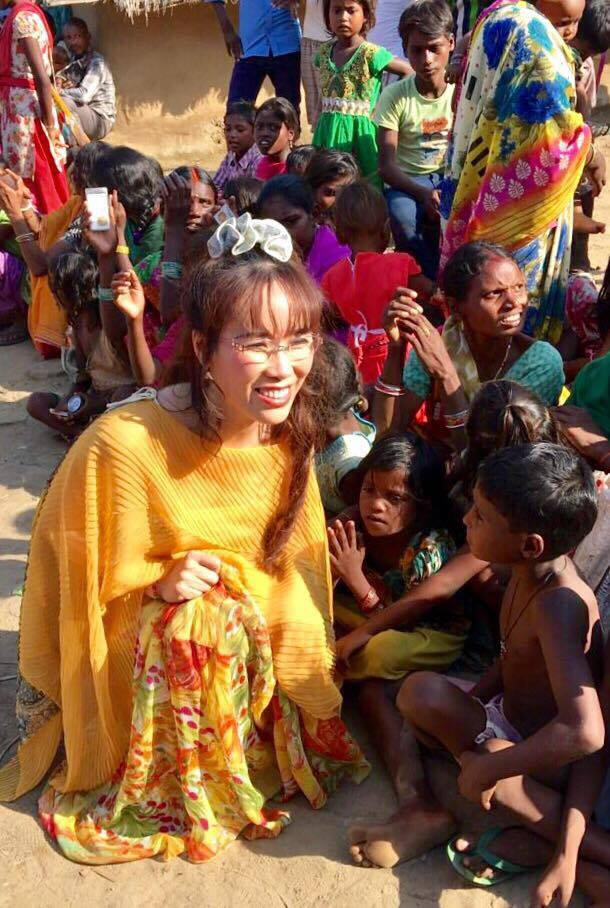 Đi nói chuyện, phát quà tại 1 làng nghèo Ấn độ trong bộ áo choàng voan hoa vàng.