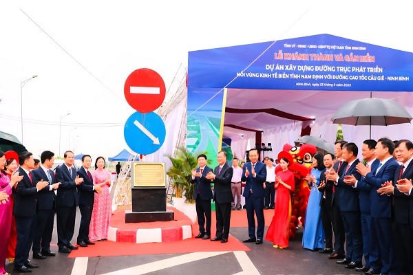 Các đại biểu thực hiện nghi thức gắn biển công trình xây dựng đường trục phát triển nối vùng kinh tế biển với đường cao tốc Cầu Giẽ - Ninh Bình.