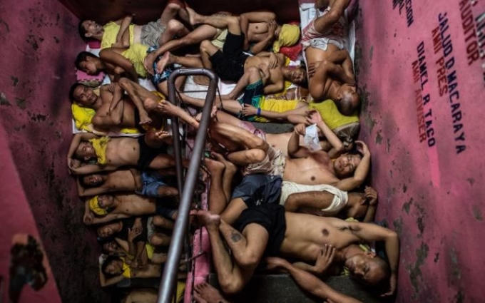 Các tù nhân nằm chen chúc nhau ở cầu thang bằng xi măng. (Ảnh: AFP)