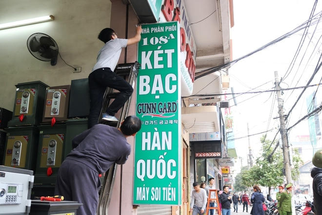 Một số hộ dân vội vàng tháo dỡ tấm biển quảng cáo đua ra vỉa hè.