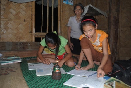 Hai chị em Hồng chăm chỉ học trong ánh đèn dầu leo lét. Ảnh Duy Ngợi
