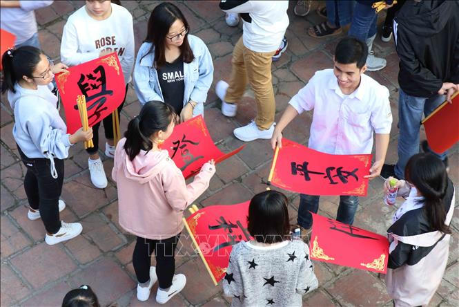 Các bạn trẻ vui mừng, hào hứng khoe chữ vừa xin được tại Văn Miếu Xích Đằng (Hưng Yên). Ảnh: Đinh Tuấn/TTXVN