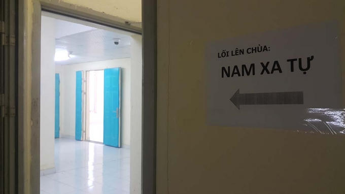 Mảnh giấy dán ở hành lang tầng 30 của tòa chung cư, hướng dẫn lối lên chùa ở tầng trên cùng. Ảnh: Nhị Tiến