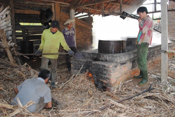 Một gia đình ở Tân Hương nhen lò nấu mật mía (ảnh Duy Ngợi).