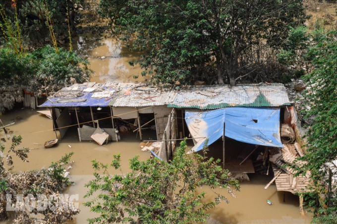 Bà N.T.H, một người sống ở đây cho biết: “Tôi chỉ mới chuyển đến đây sống. Mùi thối thì thối thật nhưng giờ chịu chứ làm thế nào. Ngày nào cũng có người thu gom rác nhưng mà không xuể được. Mấy hôm nước lên tôi lo quá, may mà không ngập lên đến nhà”. Ảnh: Phan Anh