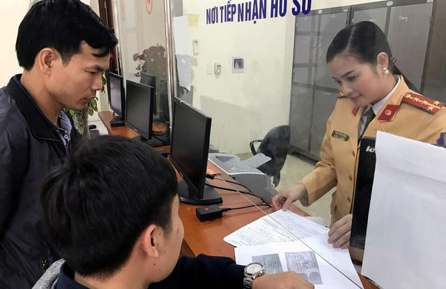 Đại úy Phạm Thị Lan Anh hướng dẫn người dân làm thủ tục đăng ký xe.