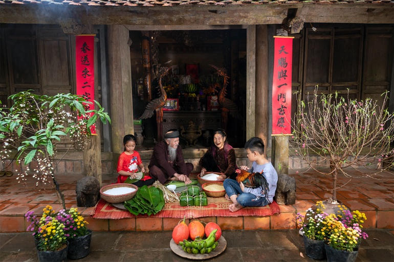 Những ngôi nhà cổ kính mang đậm nét đặc trưng ở làng cổ Đường Lâm được trang trí câu đối đỏ, cành đào, chậu hoa,... tràn ngập không khí Tết.