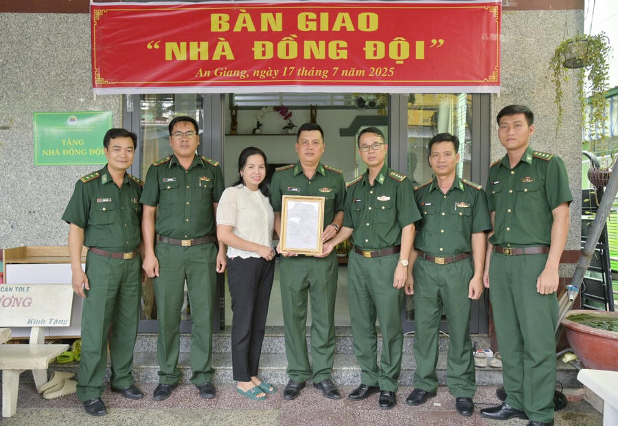 Đại tá Doãn Đình Tránh - Phó chính ủy Ban Chỉ huy Bộ đội Biên phòng tỉnh An Giang bàn giao nhà cho Thượng úy Cao Văn Sắc - Huấn luyện viên chó chiến đấu, Tiểu đoàn Huấn luyện - Cơ động