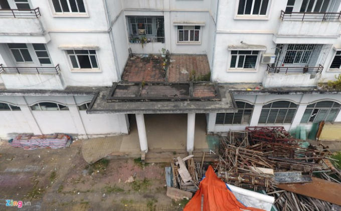 Do bị bỏ hoang nhiều năm nay nên nhiều khu vực của tòa nhà đã được trưng dụng cho những mục đích khác, vật liệu nằm ngổn ngang chắn cửa tòa nhà (Ảnh: Zing)