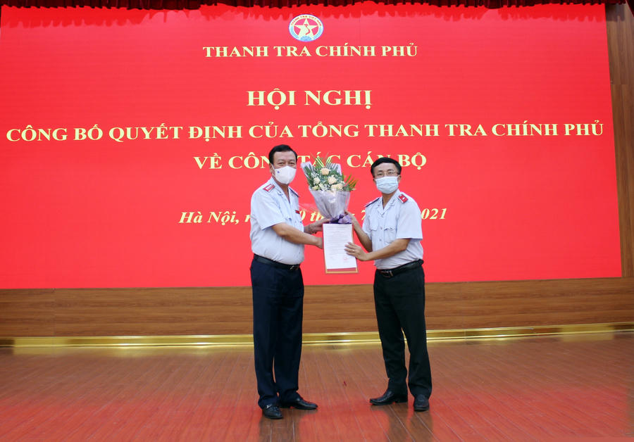Tổng Thanh tra Chính phủ Đoàn Hồng Phong trao quyết định và tặng hoa chúc mừng tân Vụ trưởng Vụ Kế hoạch - Tổng hợp Trần Đăng Vinh. Ảnh: PH