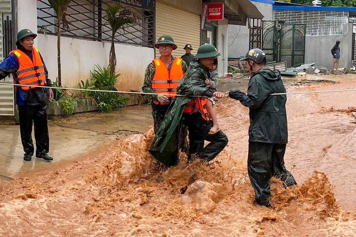 Lực lượng chức năng đưa người dân ra khỏi vùng nguy hiểm.