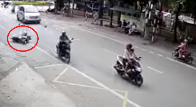 Nam thanh niên mắc vào xe máy của mình, bị kéo lê hàng chục mét. Ảnh cắt từ clip.