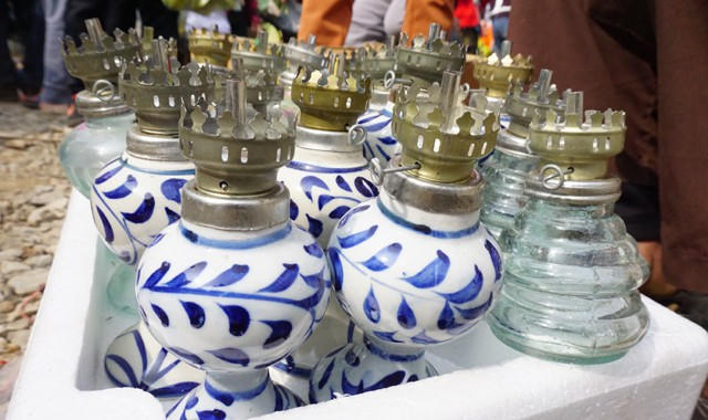 Phiên chợ cuối năm, người xa quê trở về có thể hoài niệm với những chiếc đèn dầu ngọn bấc. Khi nhiều gia đình chọn những chiếc bóng đèn điện nhỏ xinh và những cây nến thắp lên bàn thờ thì những chiếc đèn dầu này cũng ít xuất hiện hơn trước