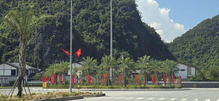 Cảnh quan núi non hùng vĩ, xen lẫn hàng cây cọ, dừa được trang hoàng cờ hoa rực rỡ.
