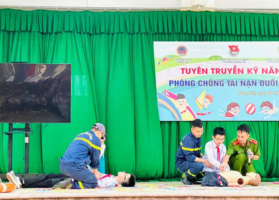 Lực lượng chức năng tuyên truyền cho các em học sinh và quần chúng nhân dân các kỹ năng phòng, chống đuối nước. (Ảnh: CATH)