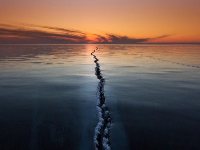 “Băng trên hồ Baikal (Siberia) là một hiện tượng thiên nhiên thú vị”, nhiếp ảnh gia Alexey Trofimov viết. “Các khe băng, vết nứt, chỗ tách rời, chỗ xô lên nhau - tất cả tạo ra những câu chuyện độc đáo và tuyệt vời”. Trong chuyến đi tới hồ nước ngọt sâu nhất và cổ nhất thế giới này, ông hy vọng chụp được một bức ảnh lạ thường trên mặt băng. Một buổi sáng, sương giá và gió mạnh đã tạo ra hình dạng đặc biệt của khe nứt. Ông cho biết: “Tôi chỉ cần chờ tới lúc mặt trời mọc để chụp bức ảnh này”. Ảnh: Alexey Trofimov.