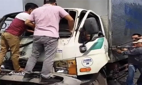 Người đi đường dùng kìm, xe beng cạy cửa giải cứu tài xế mắc kẹt trong cabin.