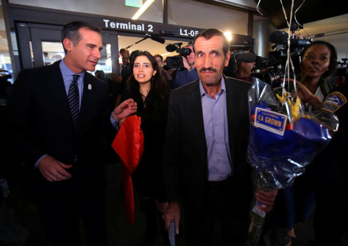 Thị trưởng Los Angeles Eric Garcetti (bên trái) dẫn đường cho anh Ali Vayeghan và cháu gái Marjan Vayeghan, người Iran ra khỏi sân bay. Anh Ali là người đầu tiên được trở lại Mỹ nhờ quyết định của tòa án liên bang California.