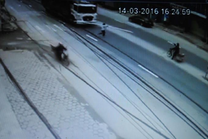 Hình ảnh nam thanh niên qua đường không hề quan sát chỉ cách ngay trước đầu xe tải trong gang tấc. (Ảnh cắt từ clip).