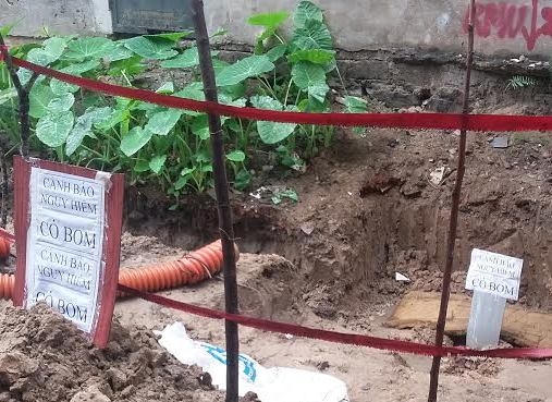 Hiện trường bị phon tỏa, cắm biển cảnh báo có bom nguy hiểm, thực ra chỉ là quả đạn pháo. (Ảnh: N. Dương)