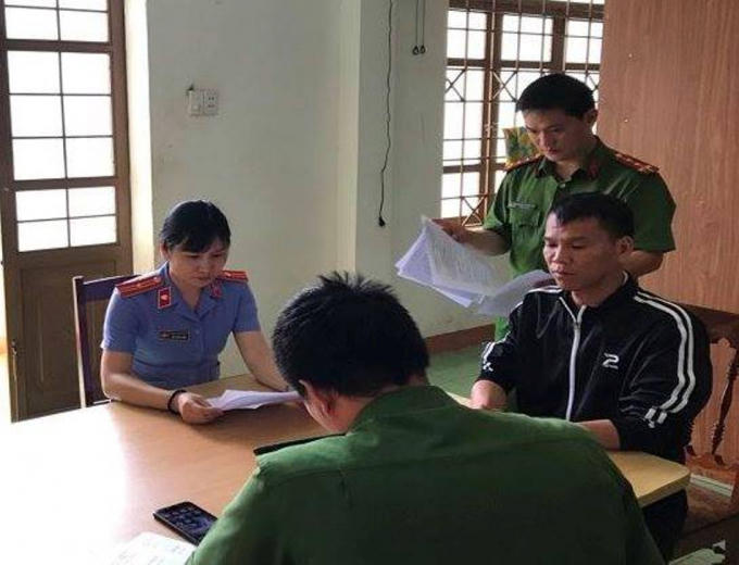 Nguyễn Duy Tuất (áo đen), tại cơ quan công an.