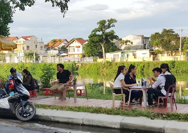 Thí sinh tranh thủ uống nước mát ngoài phòng thi.