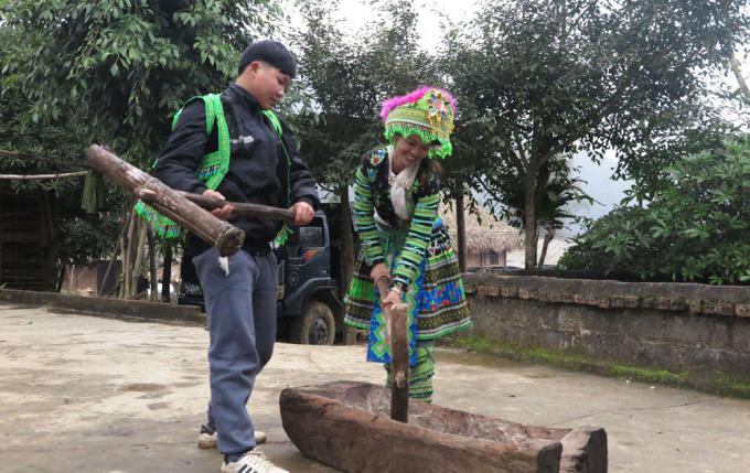 Đôi nam nữ chuẩn bị giã bánh cúng tổ tiên.