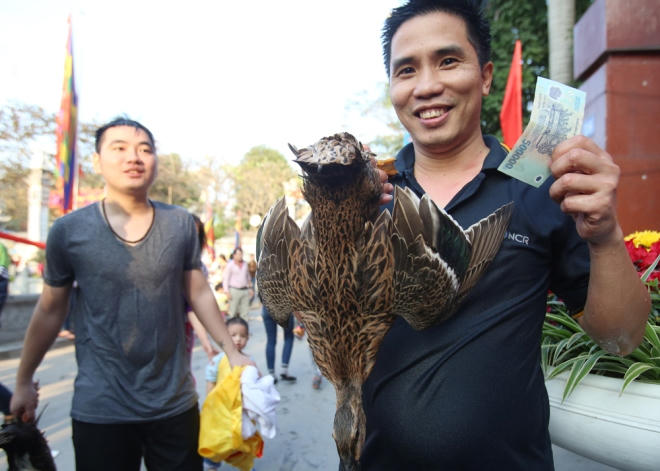 Anh Phí Văn Thành vui vẻ mang theo chú vịt vừa bắt được từ dưới ao đi nhận giải thưởng.