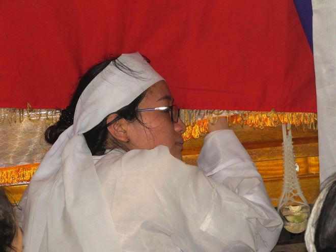 Con gái đầu của vợ chồng ông Nguyền bần thần ôm quan tài cha trước lúc chia xa.