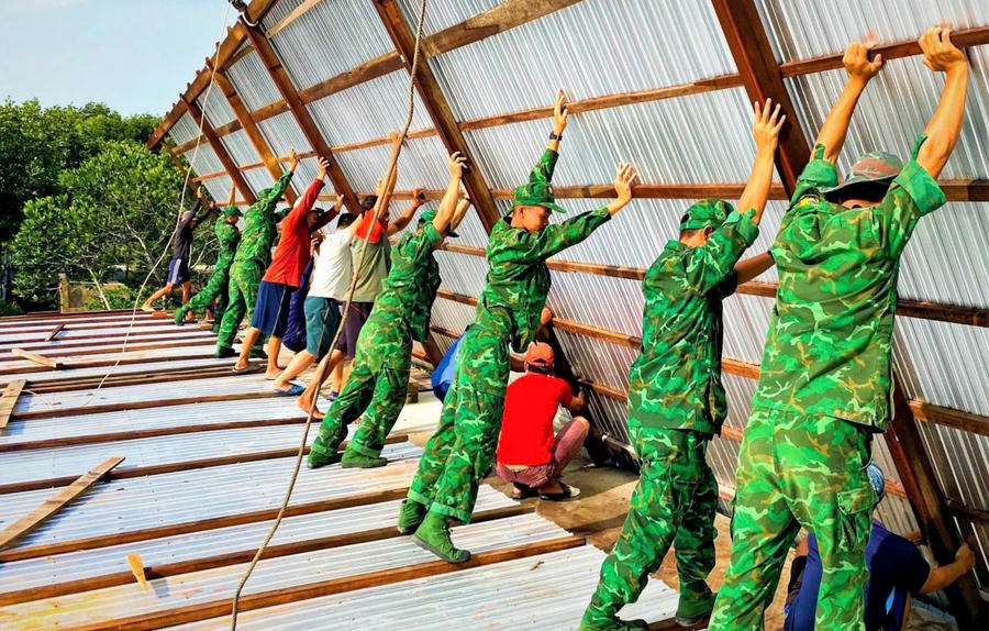 Cán bộ, chiến sĩ Đồn Biên phòng Khánh Hội giúp Nhân dân dựng lại nhà mới.