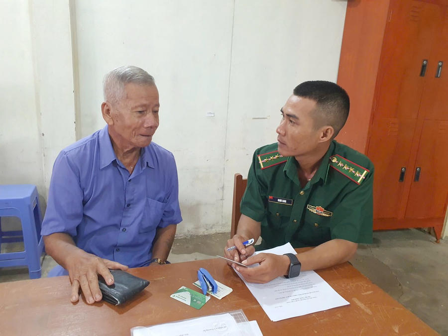 Cán bộ Đồn Biên phòng Gành Hào hỗ trợ người già thực hiện các thủ tục hành chính công theo quy định.
