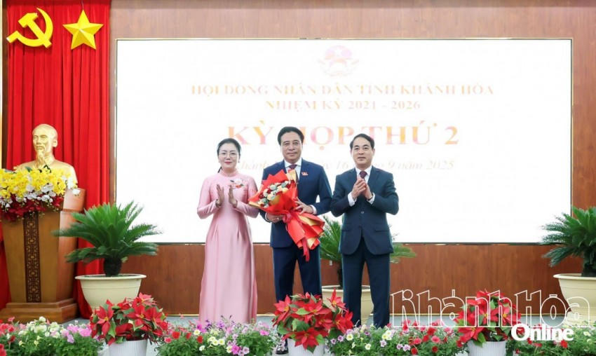 Bí thư Tỉnh ủy Nghiêm Xuân Thành và Phó Chủ tịch HĐND tỉnh Phạm Thị Xuân Trang tặng hoa chúc mừng tân Chủ tịch UBND tỉnh Nguyễn Khắc Toàn. Ảnh: Báo Khánh Hòa