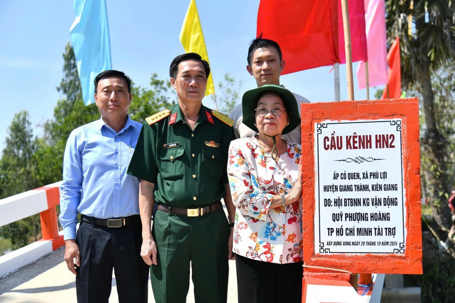 Đại diện Quỹ Phượng Hoàng TPHCM và Sở, ngành, chính quyền địa phương bên cầu HN2 được xây dựng tại xã Phú Lợi. Ảnh: Phương Vũ.