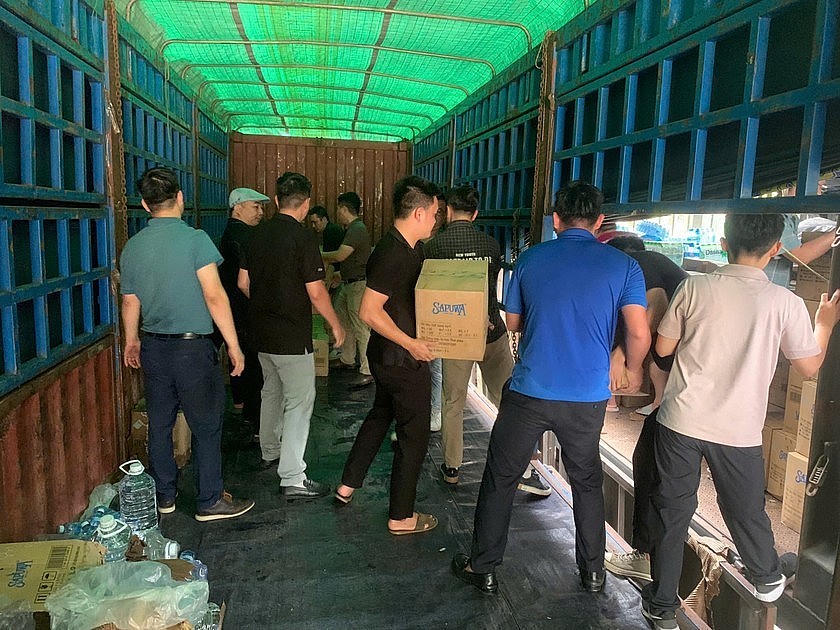 Từng lọ thuốc, từng chai nước, từng thùng quà mang theo tình yêu thương, sự chia sẻ được các phóng viên Báo Pháp luật Việt Nam truyền tay nhau đưa lên xe để đến với đồng bào vùng tâm lũ.