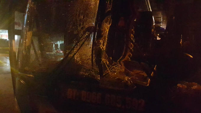 Kính trước của xe khách bị vỡ tung.