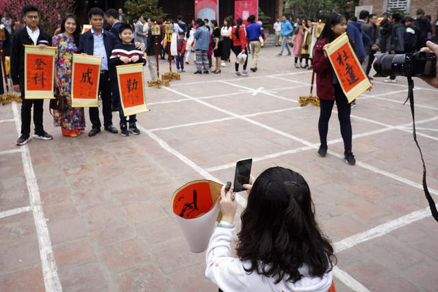 Nhiều người sau khi xin được chữ như ý đã cùng nhau chụp lưu niệm bên trong ngôi trường đại học đầu tiên của Việt Nam.