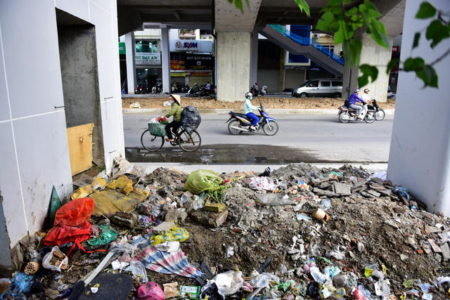 Rác thải chất đống, bốc mùi nồng nặc dưới cầu thang nhà ga Hoàng Cầu.