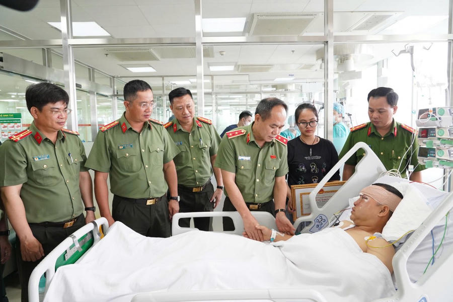 Đồng chí Giám đốc CATP Hà Nội - Trung tướng Nguyễn Thanh Tùng cùng đoàn công tác trao quà, Bằng khen cho Đại úy Lê Đình Công. (Ảnh: CATP Hà Nội)