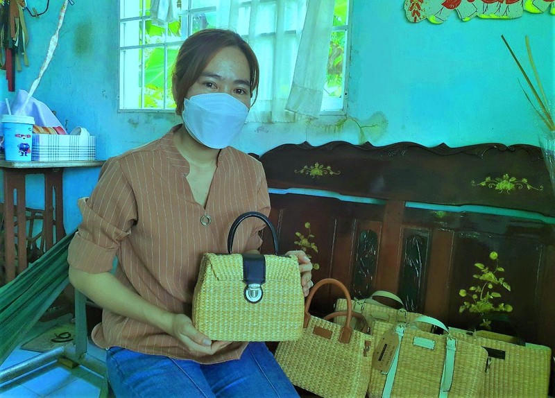 Chị Hồng Nguyên bên những chiếc túi xách làm từ bồn bồn do chính mình làm ra.
