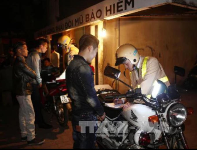 Lực lượng công an Tổ công tác 141 xử phạt người điều khiển xe máy vi phạm Luật Giao thông đường bộ đêm giao thừa. Ảnh: Doãn Tấn/TTXVN