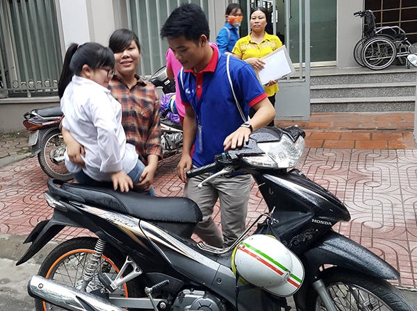 Các bạn tình nguyện viện giúp đỡ em Hải để đưa em đến điểm thi tại trường ĐH Thương Mại sáng ngày 2/7.