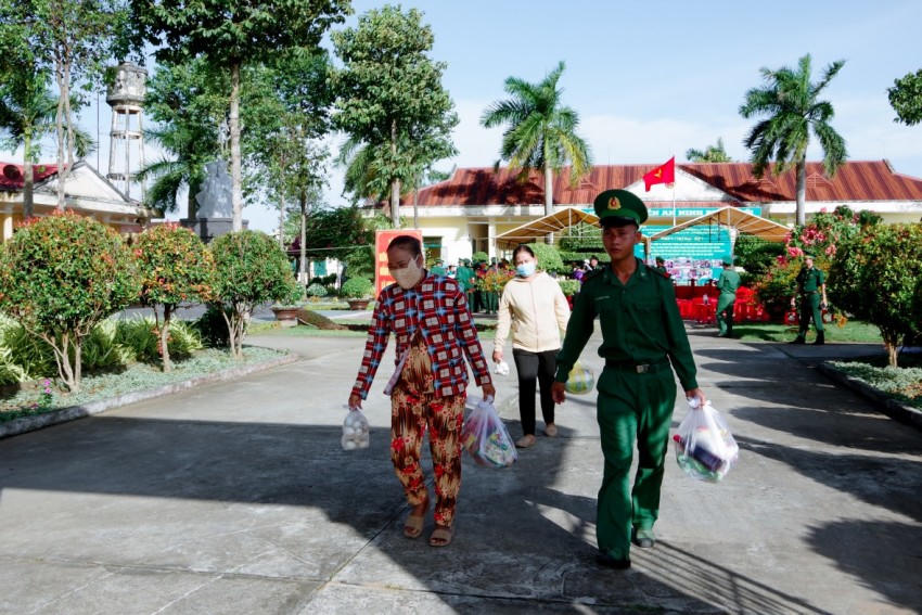 Các chiến sĩ đồn Biên phòng Lai Hòa hỗ trợ người dân đến nhận quà.